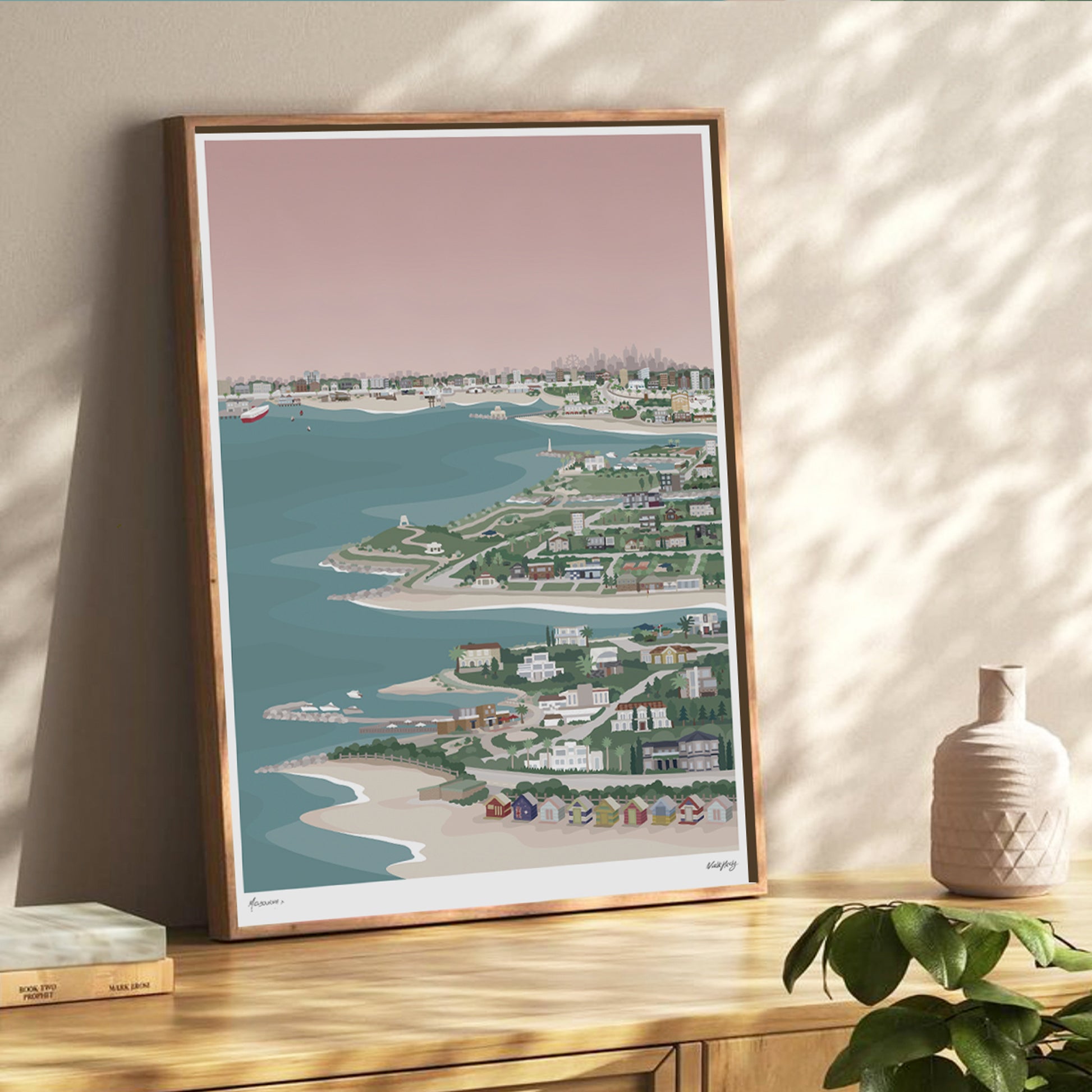 framed colourful art print of bayside Melbourne from Princes pier to Brighton bathing boxes displayed on a dresser